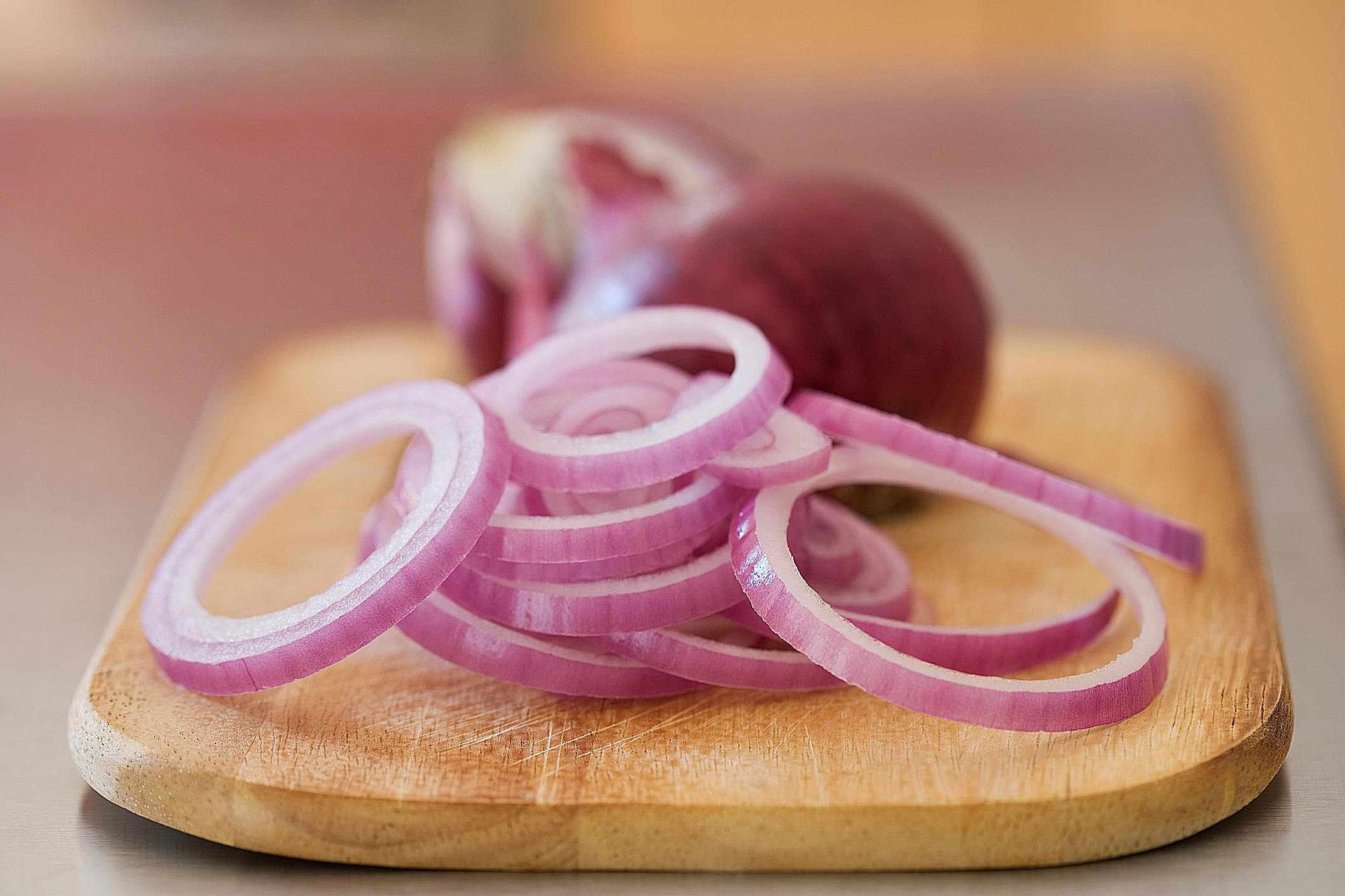Red onions sliced on cutting board
