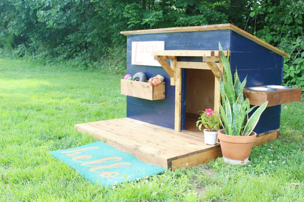 A blue dog house with a deck