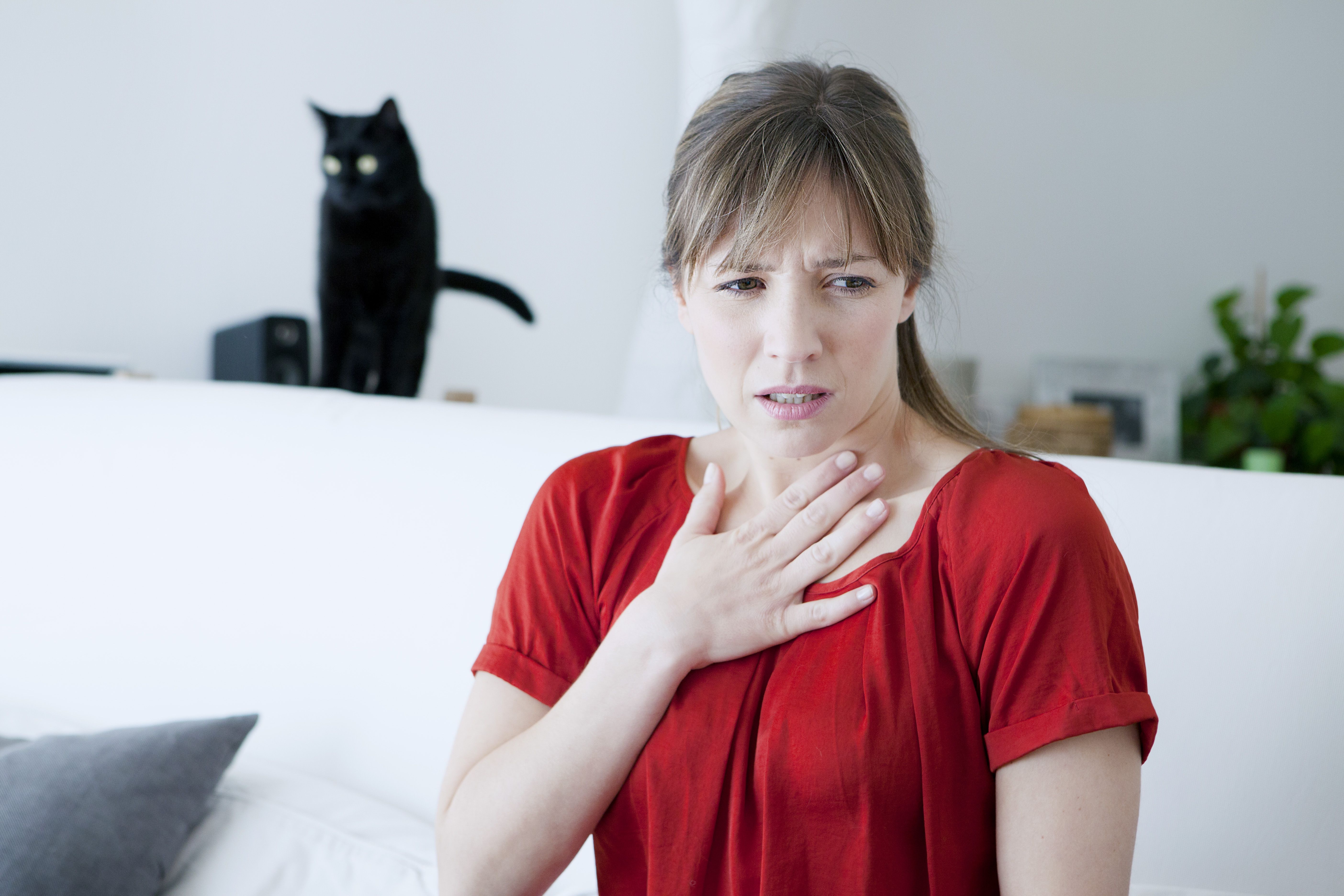 Woman dealing with allergies with a cat nearby