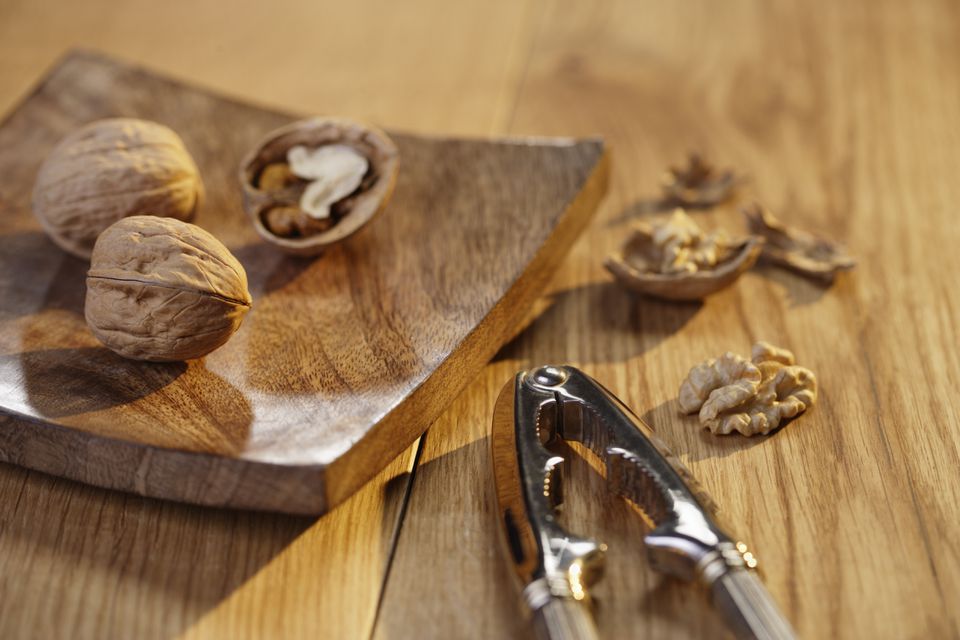 Walnut pieces and nutcracker on cutting board, close-up