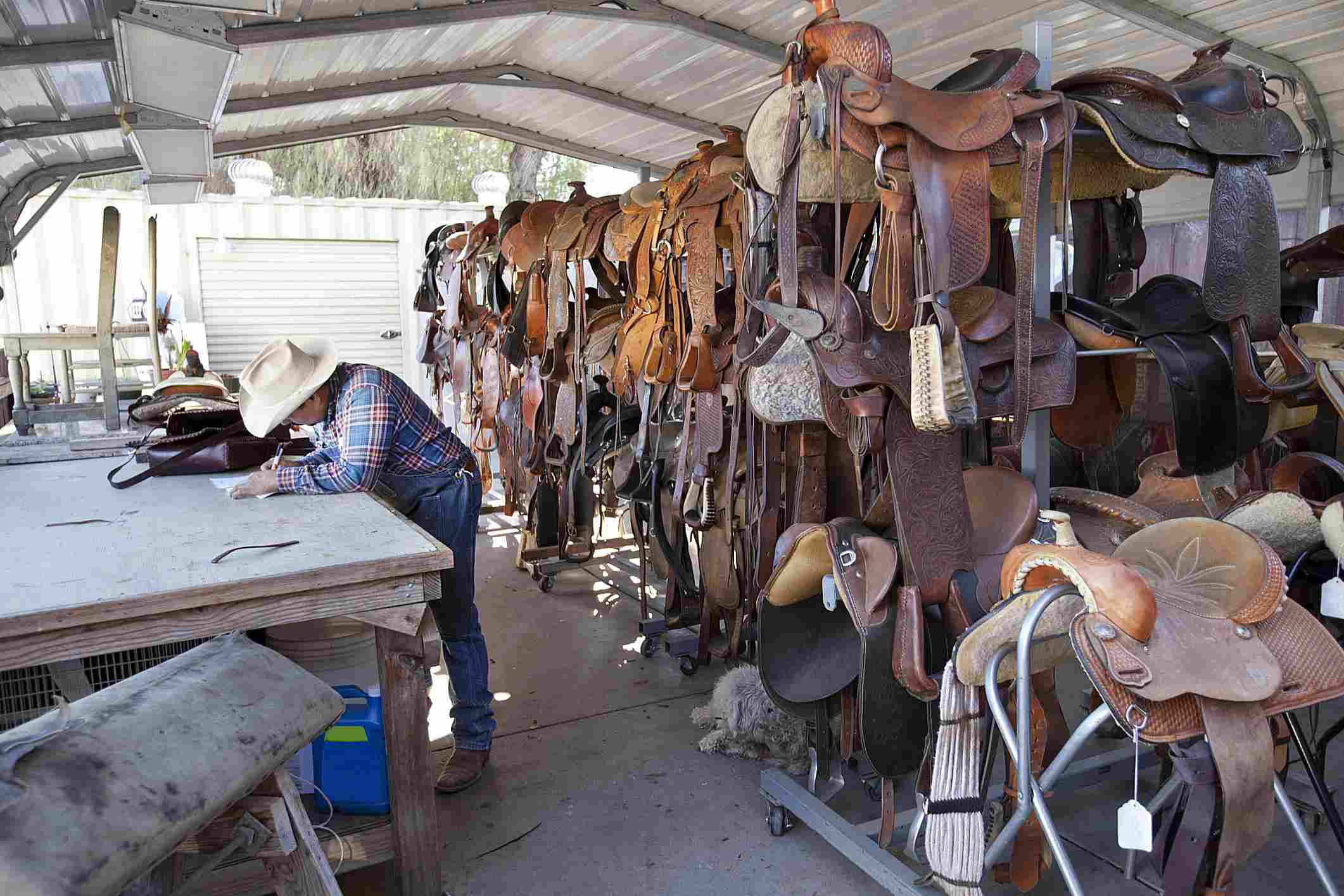 Saddler working in his saddle shop