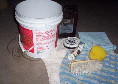 Equipment for cleaning a saddle, including a brush, sponge, bucket, and rags.