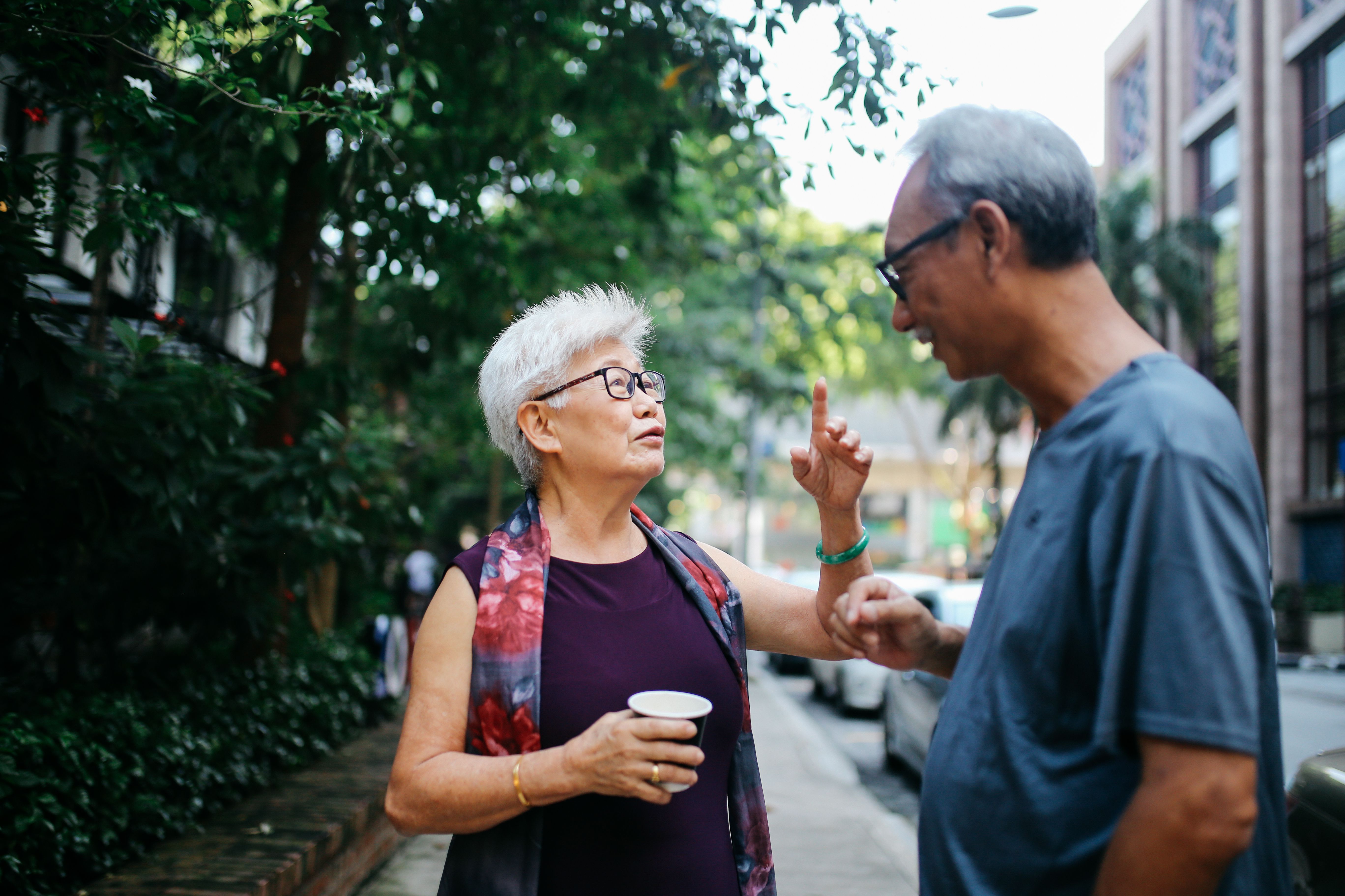 Senior man and woman talking on the street