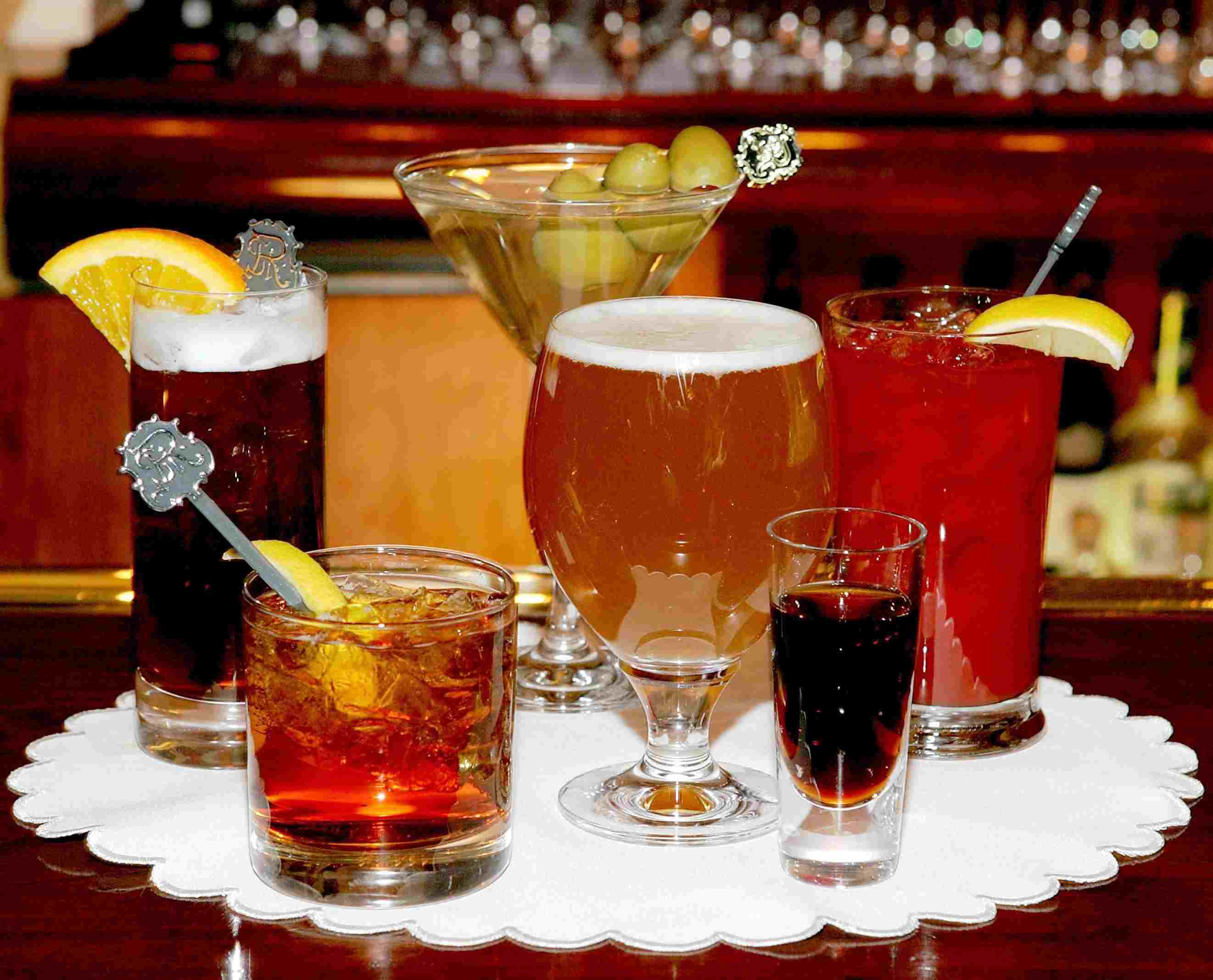 A variety of alcoholic drinks on a table, including beer, shots, and hard liquor., also toxic to dogs