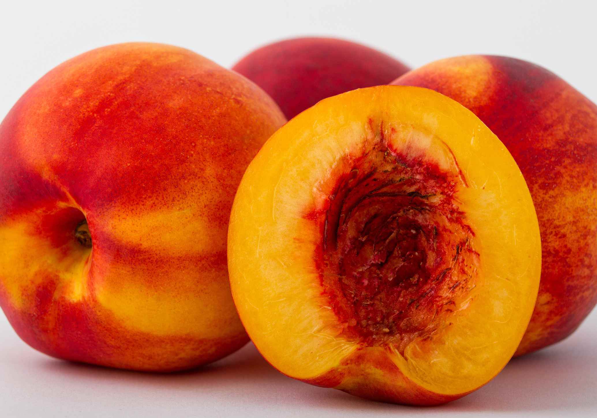 Peaches with one cut open and the pit removed.
