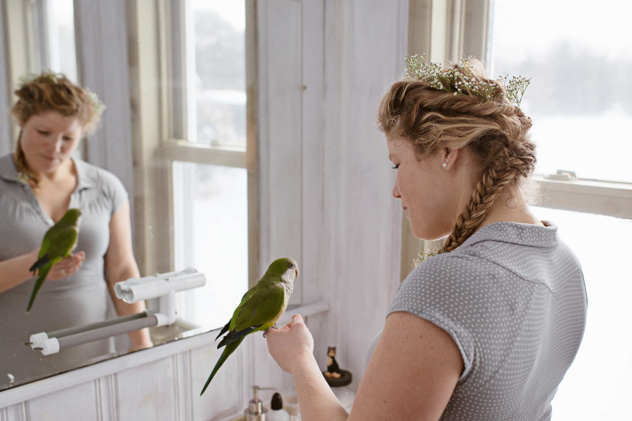 Woman talking to a quaker parrot