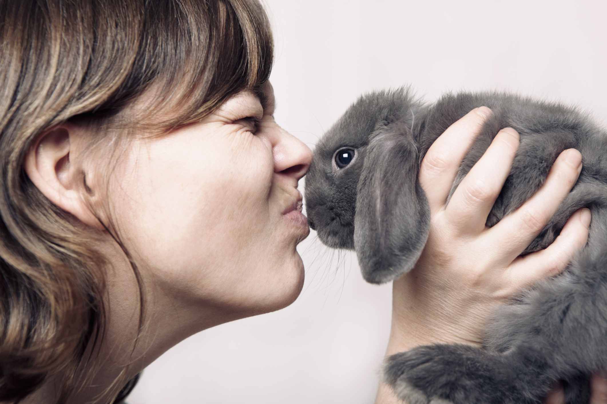 A woman kissing a rabbit