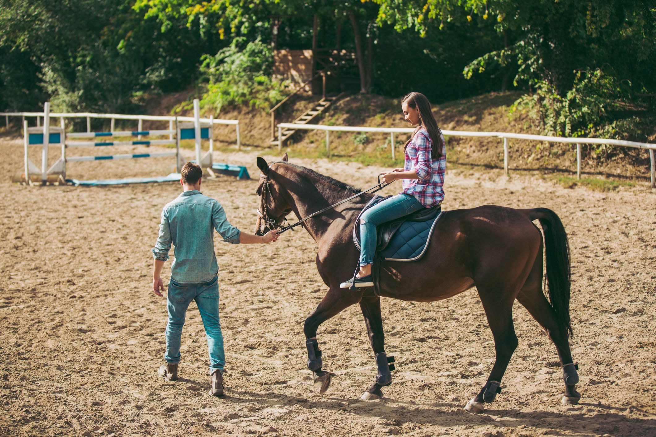 Young woman training horseback riding technique with instructor