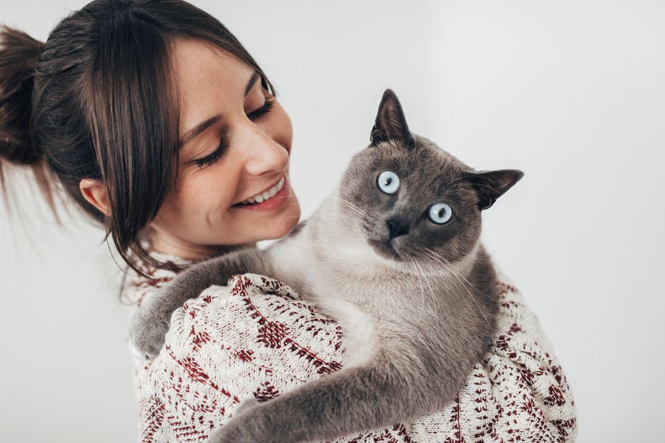 Cat looking at the camera while being held by a woman